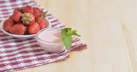 A white plate with ripe strawberries is on a napkin