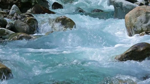 Stormy stream on the mountain river on a sunny day.