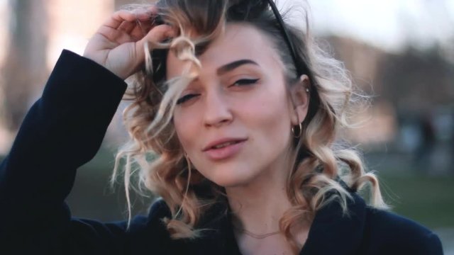 Curly beauty woman using her sunglasses and drinking coffee and tea in red glasses.