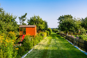 Garden path and summer children house in the garden, cottage playhouse for kids © alicja neumiler