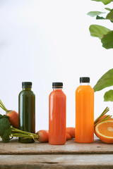 Various bottle of juice on a wooden table in the garden