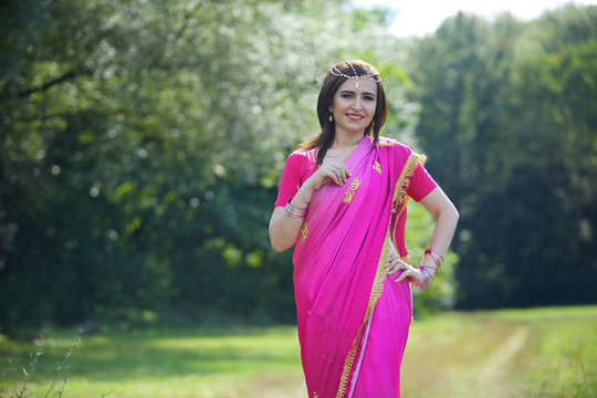 The girl, dressed in a Sari of Indian culture.