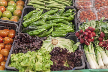 Market display various vegetables in boxes.