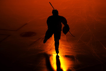 one  man ice hockey player in arena silhouette isolated on black background