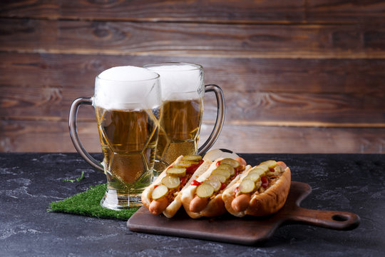 Photo of two glasses of beer, hot dogs, soccer ball