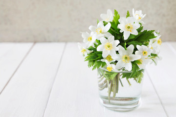 Bunch of white spring flowers in a glass