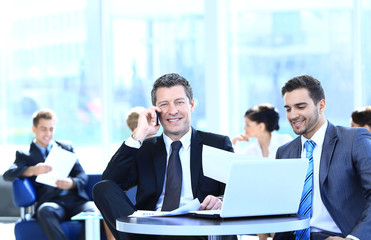 serious businessman talking on mobile phone sitting at your Desk