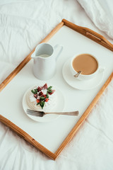 Cozy home breakfast in bed in white bedroom interior 