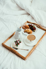 Cozy home breakfast in bed in white bedroom interior 