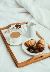 Cozy home breakfast in bed in white bedroom interior 