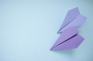Two paper planes on colorful background.