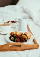 Cozy home breakfast in bed in white bedroom interior 