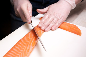 Sushi master, cutting sushi rolls. Making sushi rolls. 