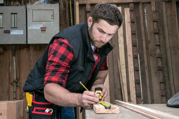 Carpenter, wood worker work measuring, drilling and making timber product