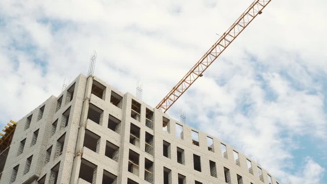 Construction cranes for building on a background of blue sky with white clouds