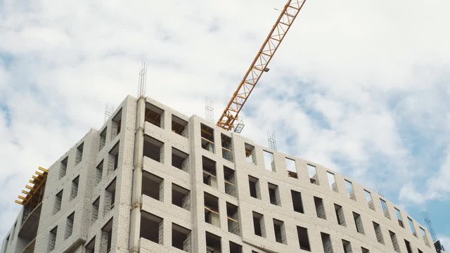 Construction cranes for building on a background of blue sky with white clouds