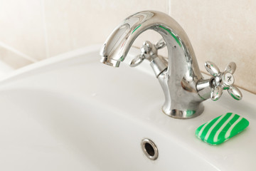 A drop of water from a water tap. Water Releasing. on a background of soap