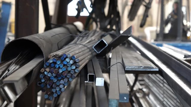 Industrial footage: Stack of thick metal bars of iron in a factory warehouse.