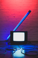 toned picture of arranged retro tv set, cables and lamp with brick wall background