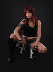 Portrait of sexy woman posing in studio with gun