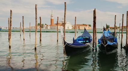 Fototapeta na wymiar The symbol of Venice is the traditional gondola boat. Rock on the waves, moored near the shore