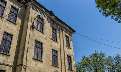 Old abandoned hospital. Medical complex. Old architecture. Architectural heritage. Majestic old building. Green trees. Blue sky. Poplar fluff