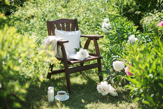 a wooden chair in the garden and a cup of tea