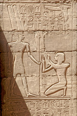 The fresco from the life of the pharaoh carved on the wall of the ancient temple of Karnak in Egypt