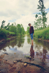 Mujer joven en mitad de la naturaleza, junto a un improvisado r&iacute;o de lluvia