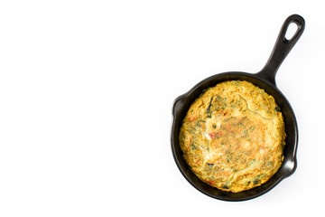 Frittata made of eggs and vegetables in a iron pan, isolated on white background. Top view