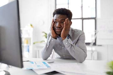 business, people, deadline and technology concept - stressed african american businessman with computer and papers at office
