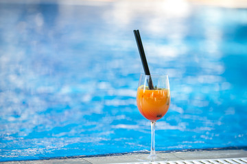 orange cocktail on swimming pool background.Summer vacation concept. Refreshing beverage.horizontal shot. copy space