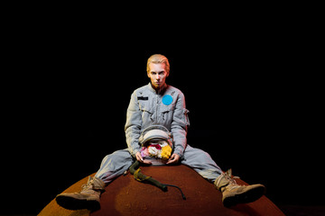 attractive female astronaut in spacesuit with flowers in helmet sitting on planet © LIGHTFIELD STUDIOS