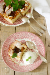 Pie with plums and peaches, served with a vanilla ice cream ball and lemon balm leaves.