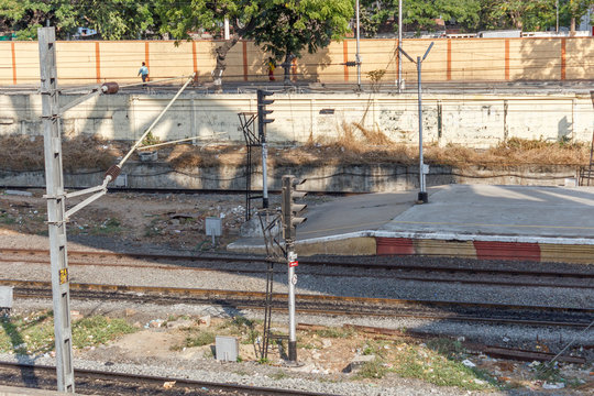 guindy railway station seen with tracks and traffic signal post with electrical posts that supply power for running the trains