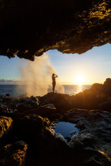 Woman watching the sunset at Le Souffleur in Saint Leu, Reunion Island