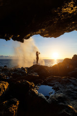 Fototapeta premium Woman watching the sunset at Le Souffleur in Saint Leu, Reunion Island