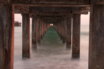 Waves sea and beach under the bridge