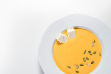 Pumpkin cream soup with cheese on white background