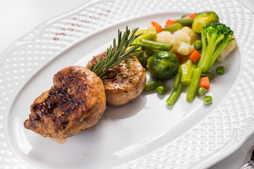 Meat steak with vegetables garnish on white background