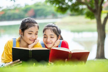 Fototapeta premium Pretty asian twins girl or students reading a book in the public park