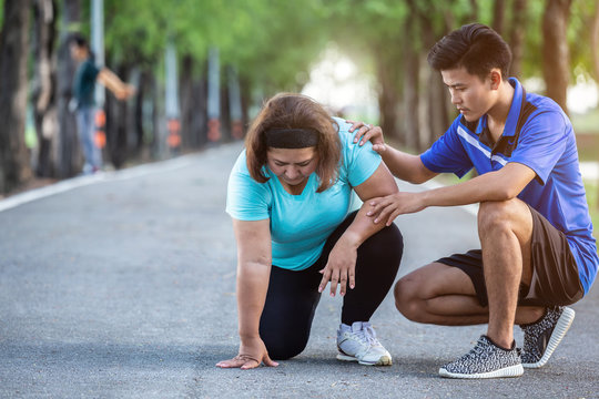 Asian man make encouragement to fat woman who sitting on ground