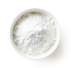 Obraz na płótnie Canvas Bowl of powder sugar on white background, from above