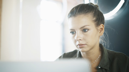 A close up portrait of a girl young pretty serious concentrated working freelancer
