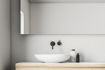 Naklejka na ściany i meble White bathroom sink in a concrete room