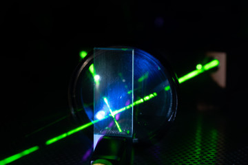 Green laser on optical table in a quantum optics lab.