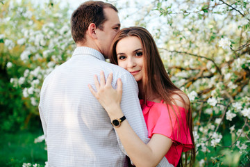 Obraz premium a young couple in love in the spring flowering Park