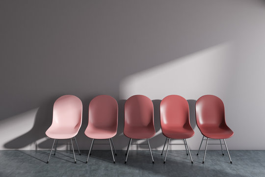 Row of red chairs in white wall room