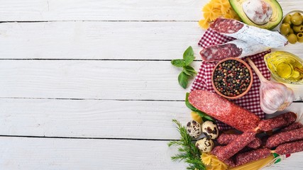 Concept of Italian cuisine. Pasta, Basil and Vegetables. On a wooden background. Top view. Copy space.