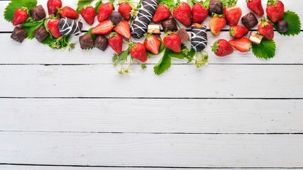 Strawberries with sweets. On a white wooden background. Top view. Copy space.